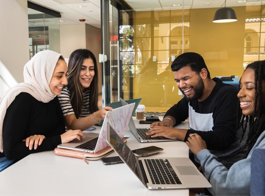 Four students at a table working together.