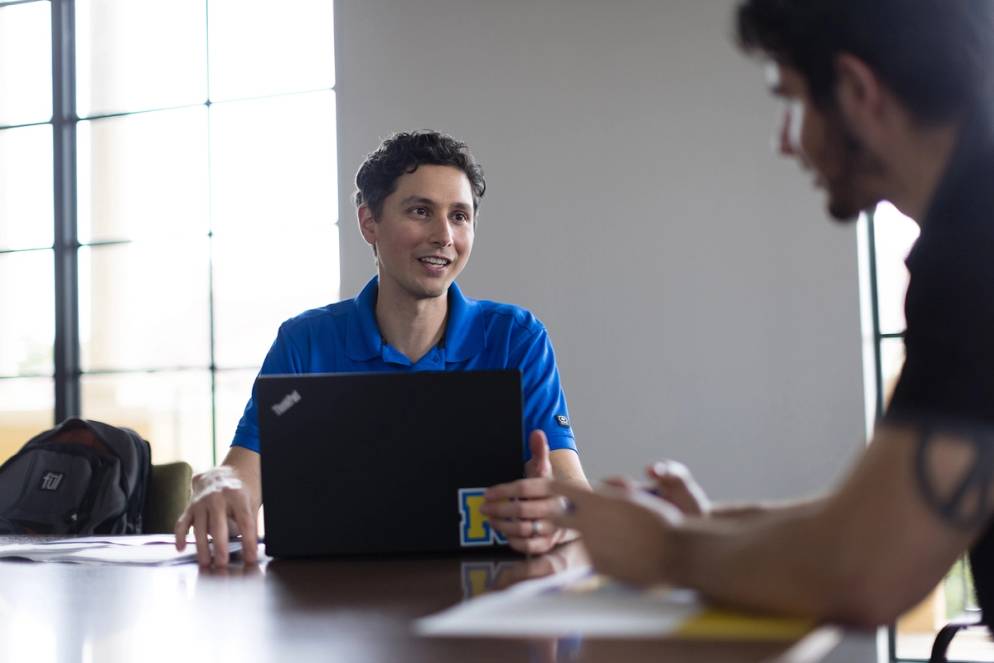 An admission counselor works one on one with a Rollins Professional Advancement student.