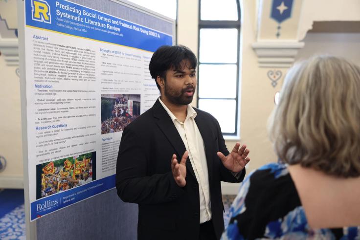 Rollins student presents his research at the Scholarship Showcase event for the presidential inauguration.