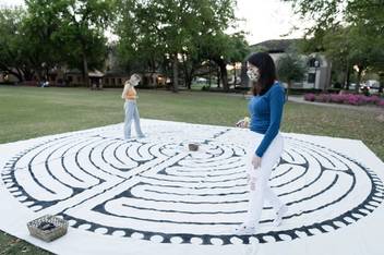 Students engage in a canvas labyrinth walk as they reflect on one year of the pandemic during the “Fiat Lux: An Evening of Remembrance and Hope” in March on Mills Lawn.