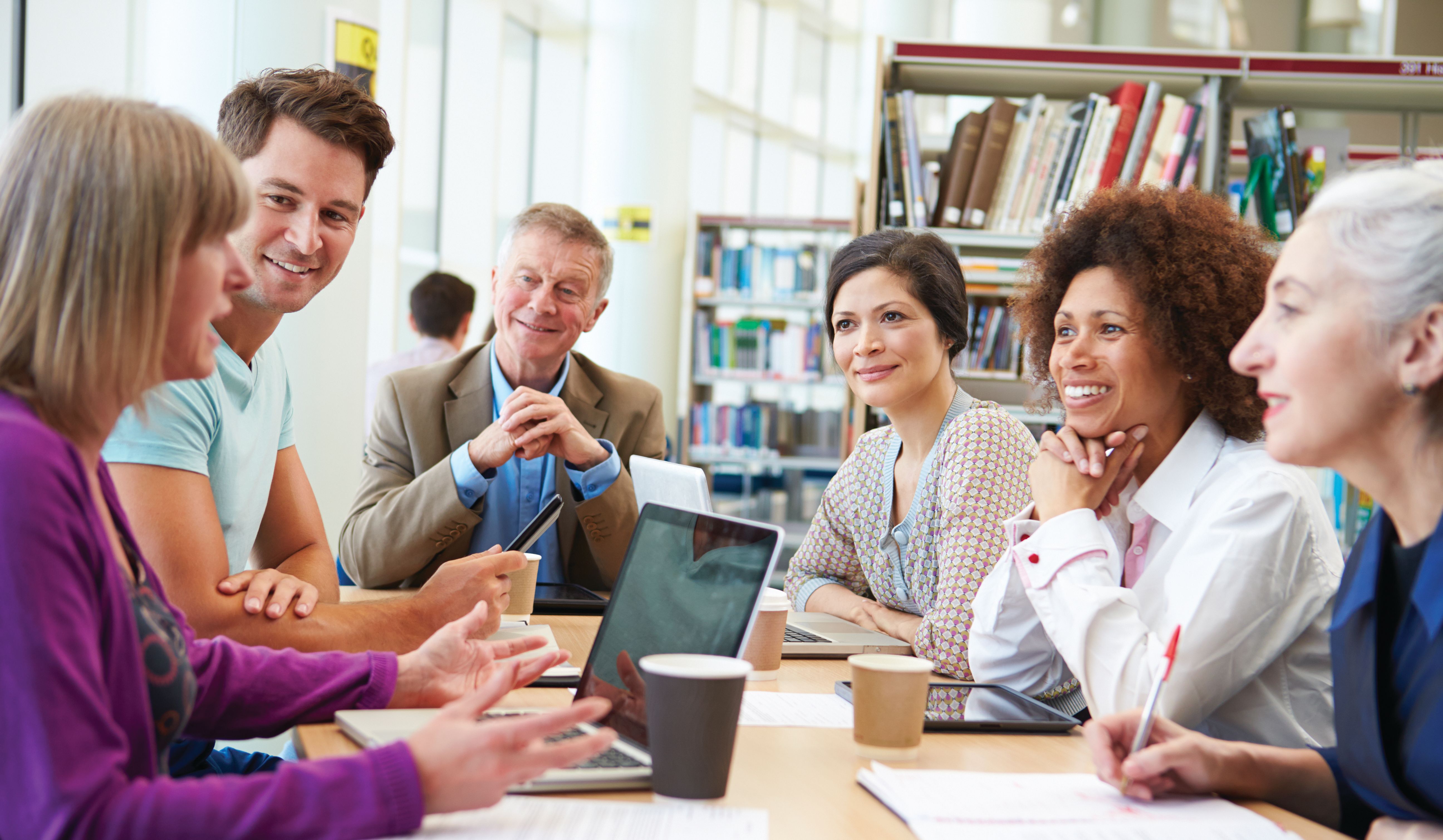 Adult learnings meet at a table in the library at Rollins College.