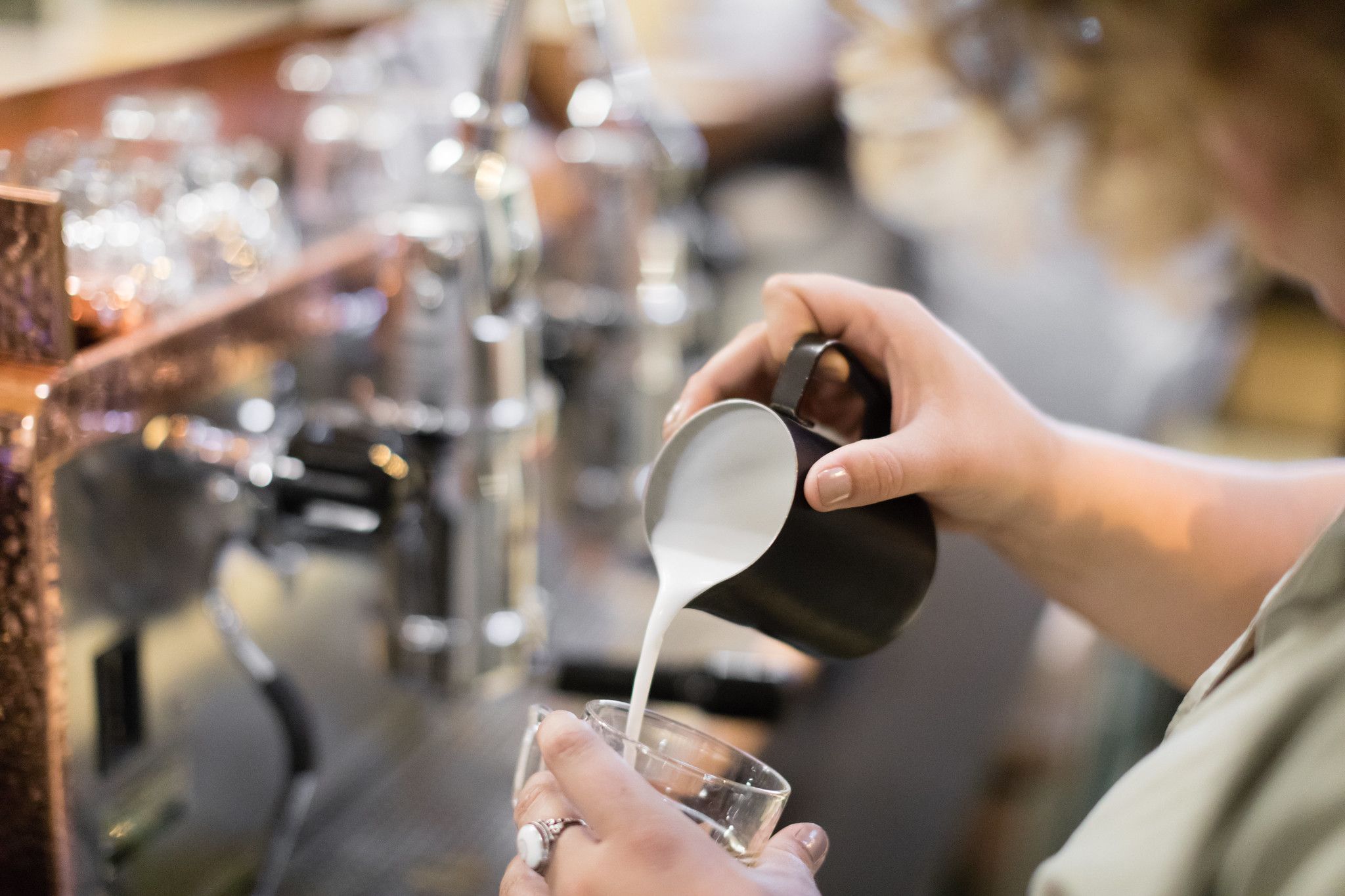 Pouring milk at Downtown Credo, a local coffeeshop that partnered with Rollins for an economics class.