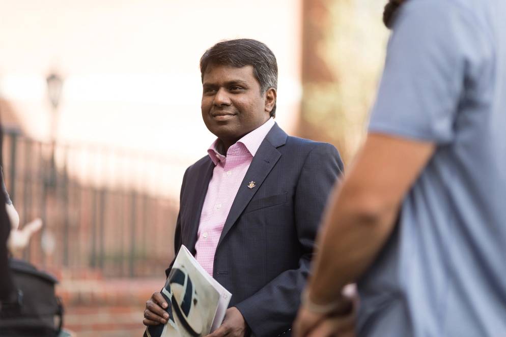 Social Entrepreneurship professor, Raja Singaram, holding a catalog.