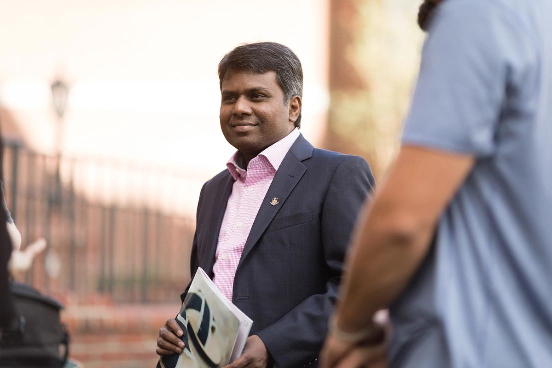 Social Entrepreneurship professor, Raja Singaram, holding a catalog.