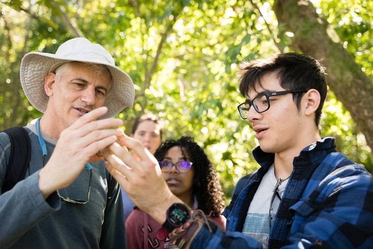Marcus Mosquera ’22 and environmental studies professor Lee Lines discuss a shell they found as part of immersive field work in Cape Canaveral, Florida.