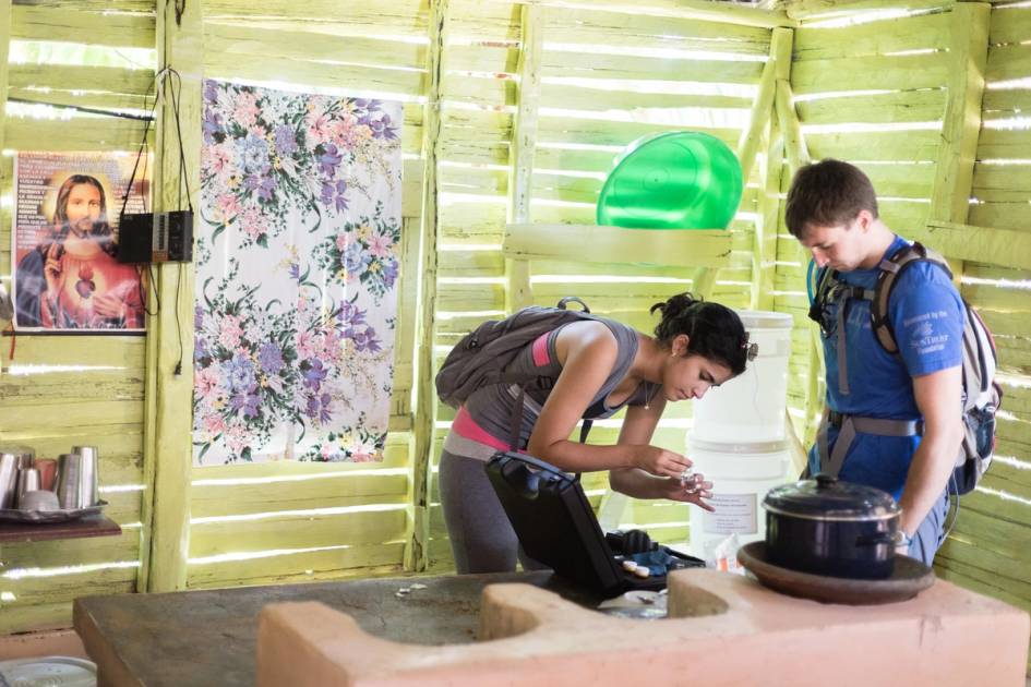 Two chemistry students test water from a filtration system in a home in the Dominican Republic.