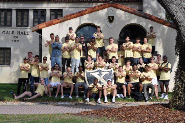 X-Club Fraternity brothers standing in front of their residence on Rollins campus.