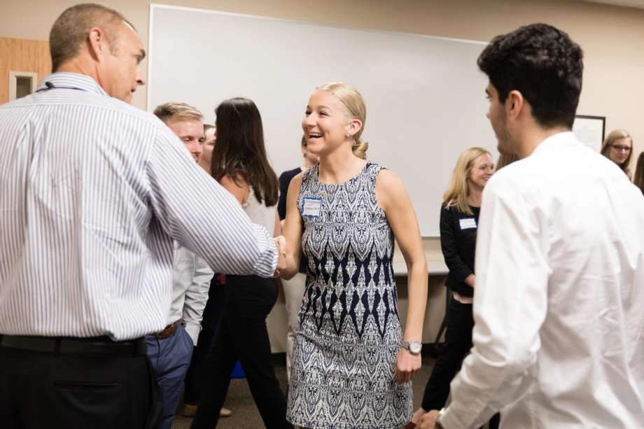 A college student greeting the CEO of a local company.