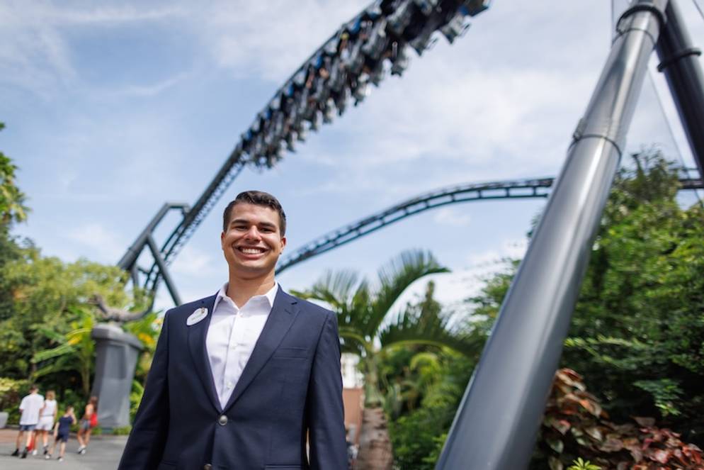 A Rollins student standing in front of a roller coaster at Universal Studios