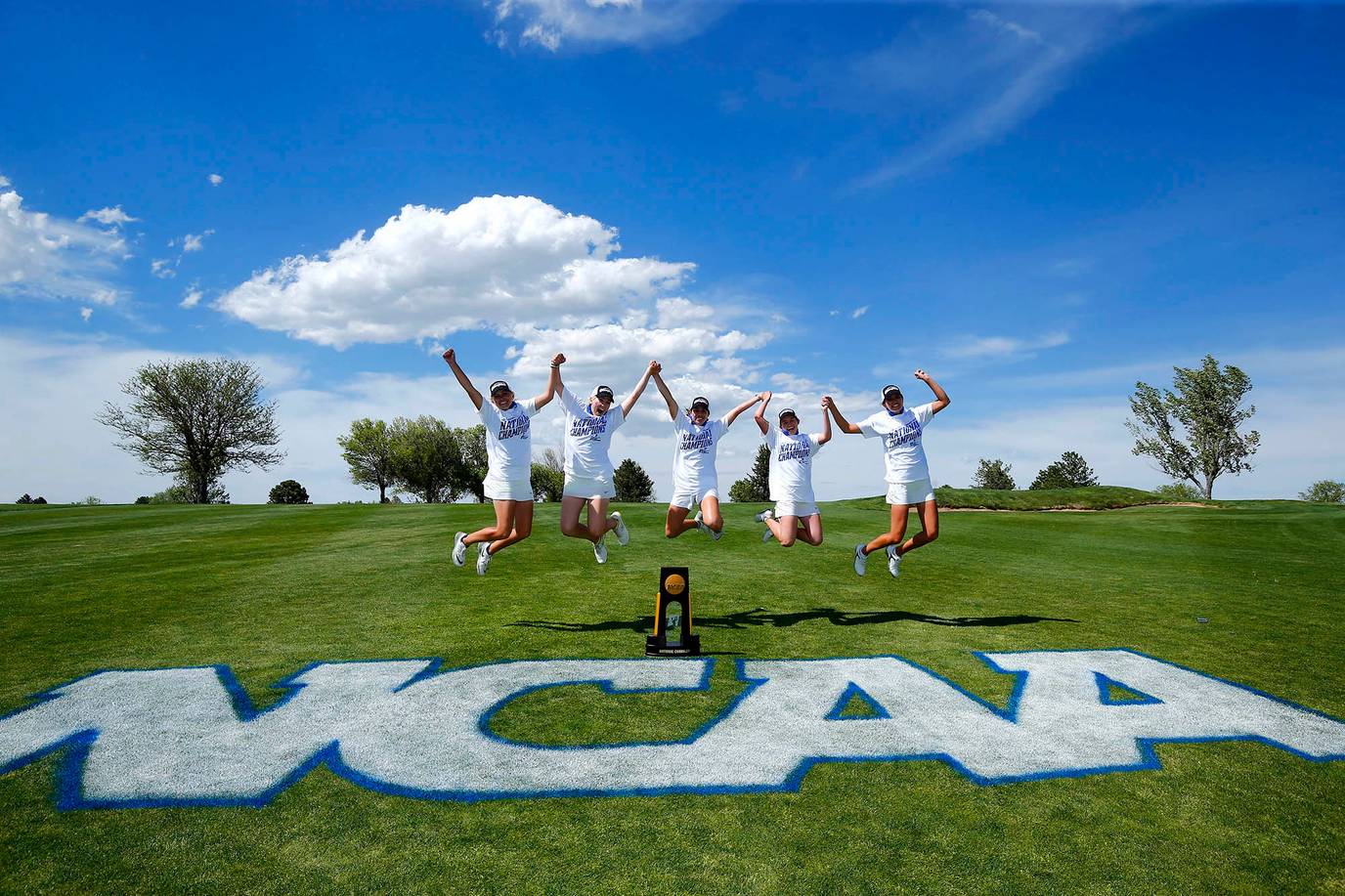 Women’s golf teaming jumping in celebration of their NCAA championship win.