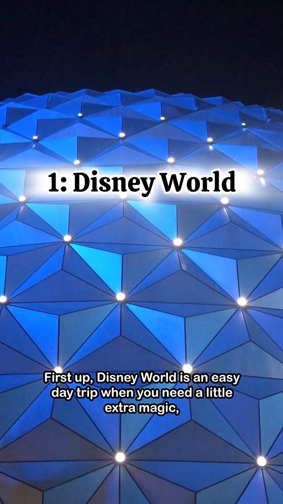 Disney World promotion over illuminated geometric blue structure at night.