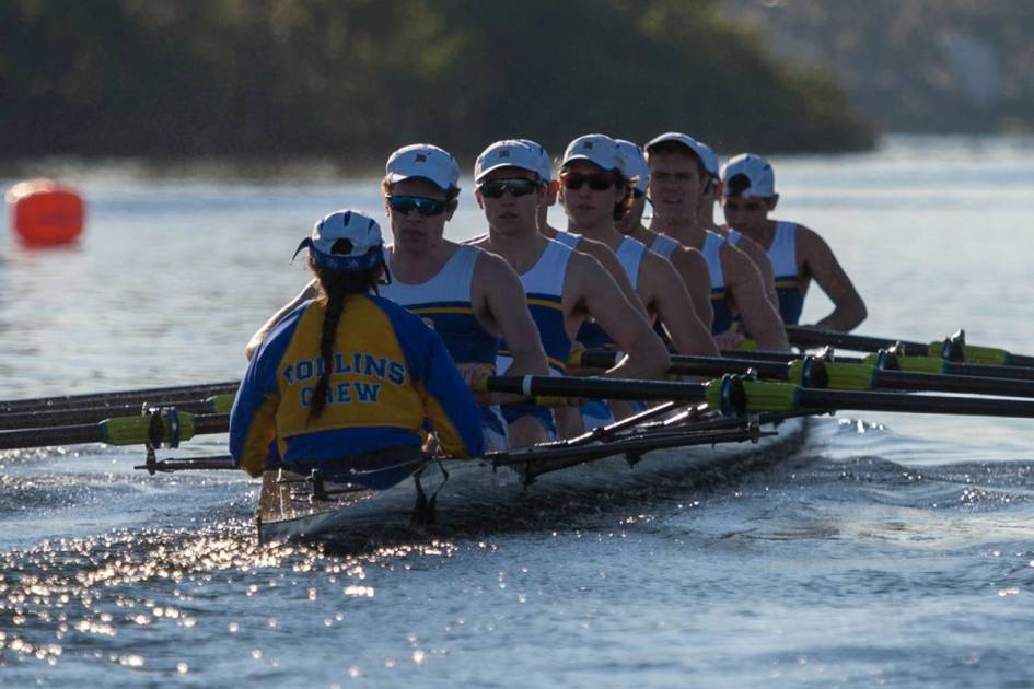 A crew team rows across the lake.