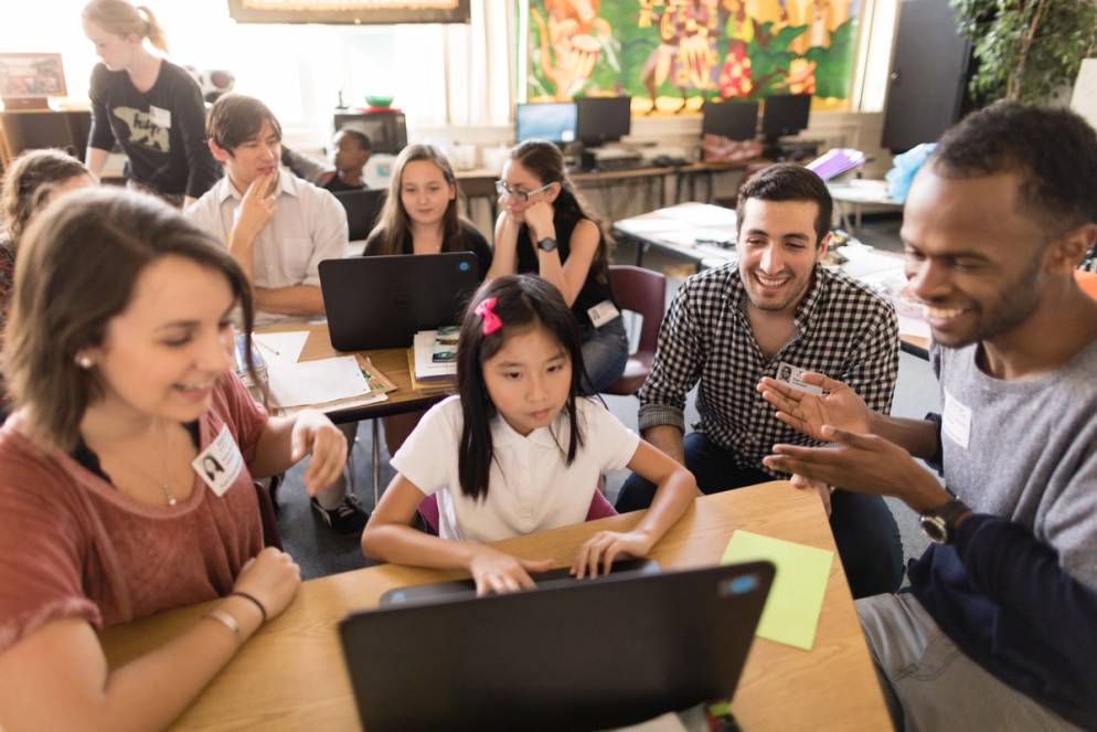 Sam Sadeh and Karina Barbesino help an elementary student learn how to code.