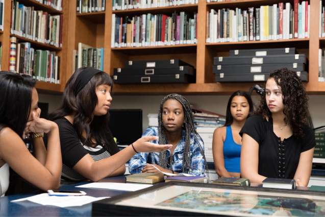 African American liberal arts college students discussing a topic at the fine arts museum on campus.