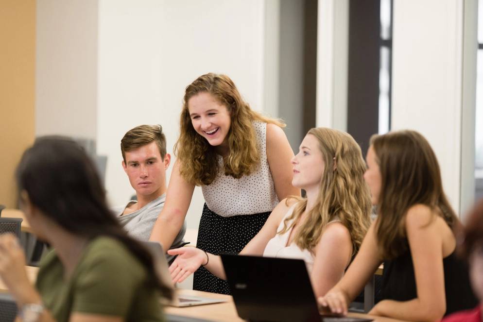 An advisor and a group of students work together during a orientation class for transfer students.