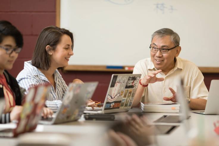 Professor and student having a discussion in a classroom.
