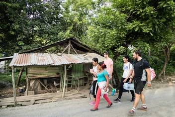 A group of students walk down a rural road during a study abroad experience in the Dominican Republic.