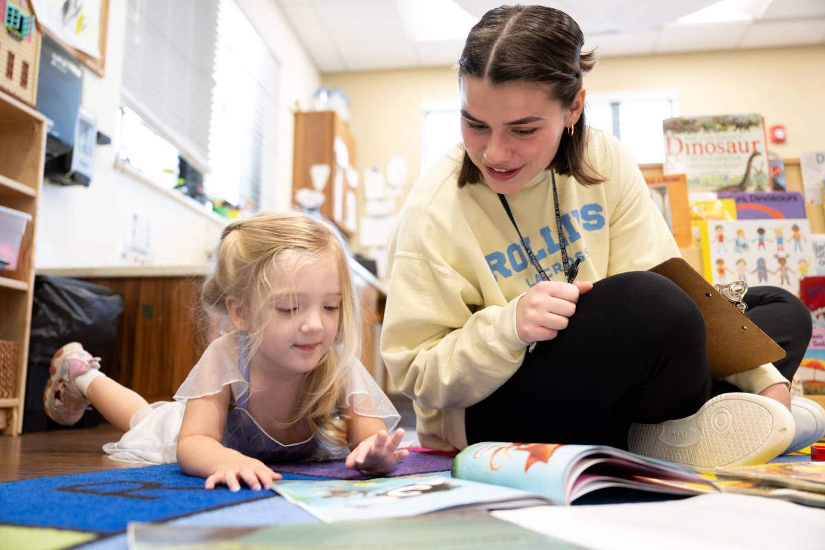 Student and child reading a book