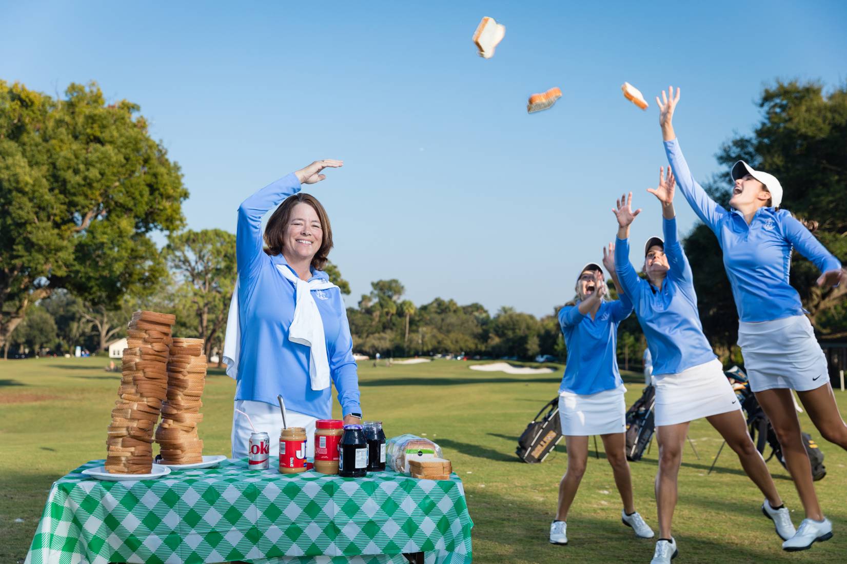 Coach Julie Garner throws sandwiches to the Rollins women's golf team.