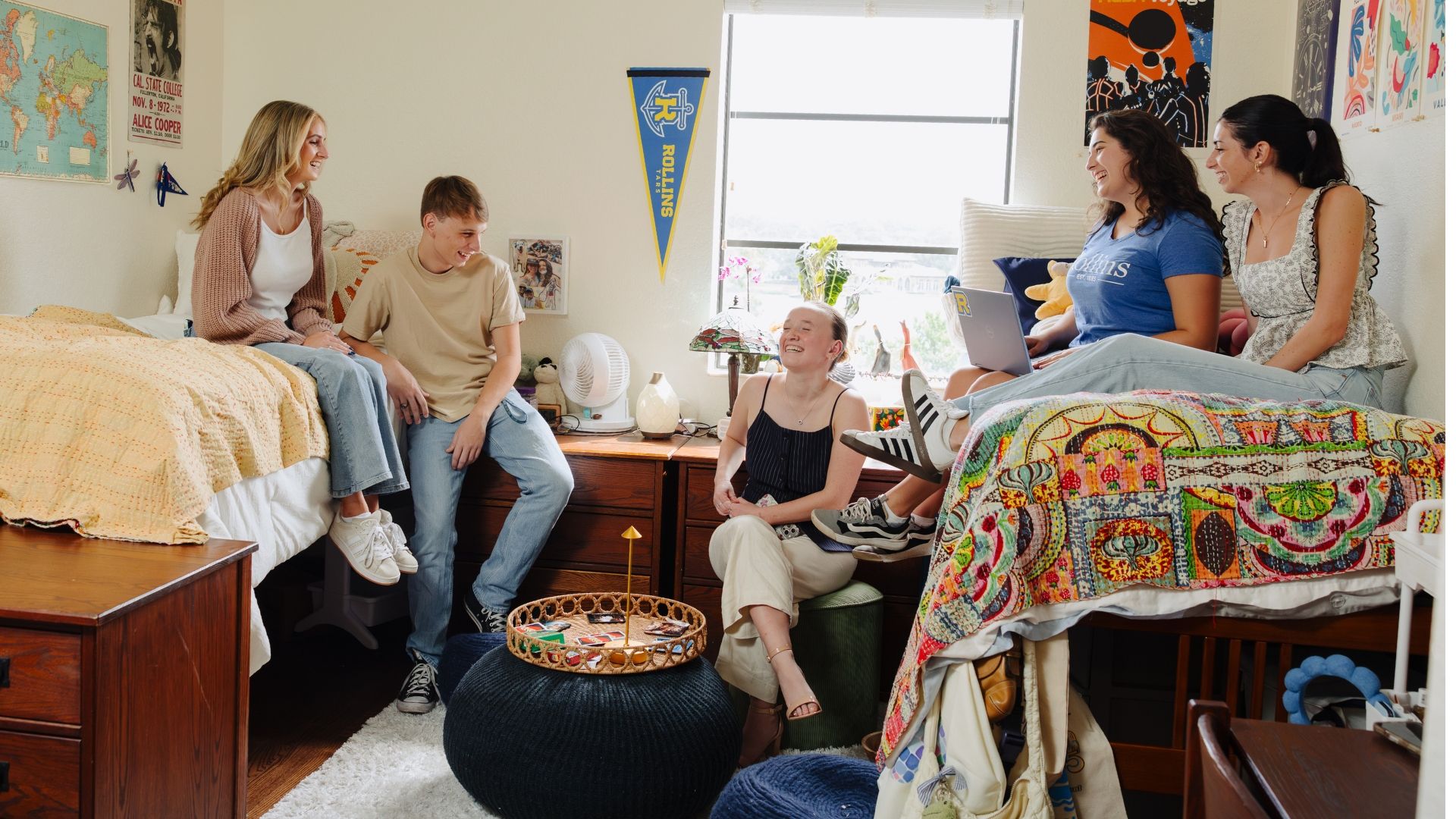 Five students laughing in a dorm.