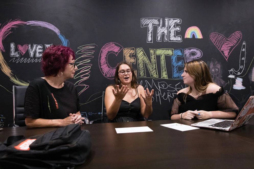 Students and history professor Claire Strom engaged in discussion about research for the LGBTQ History Museum of Central Florida.