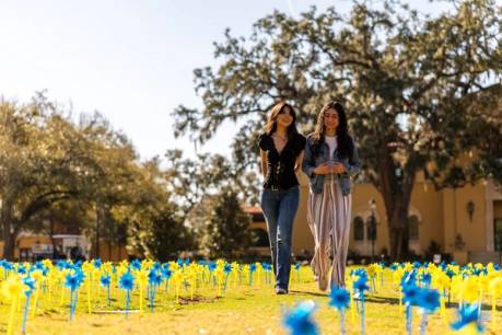 Two Rollins students walk through Mills lawn.