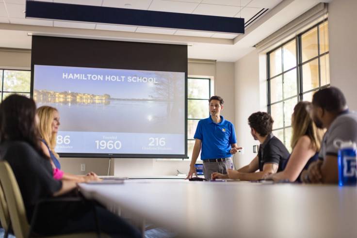 Classroom of students facing a large screen saying Hamilton Holt School.