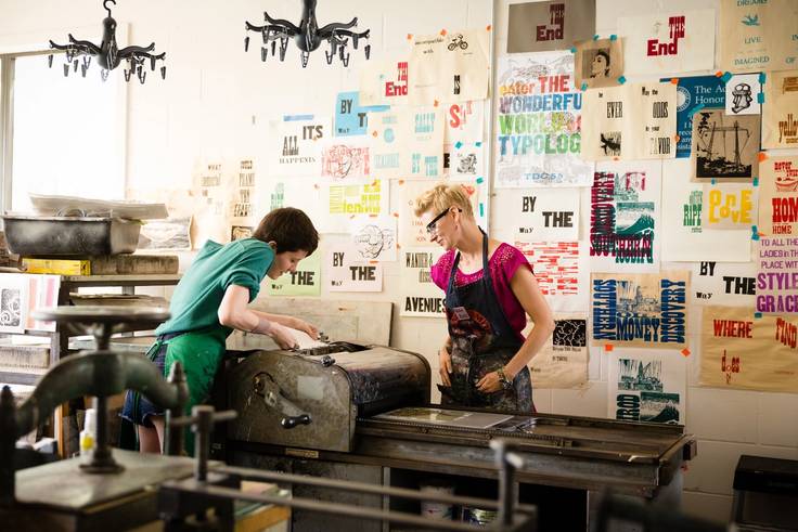 Rachel Simmons teaching letter press techniques on 1950's printing equipment during her art class.