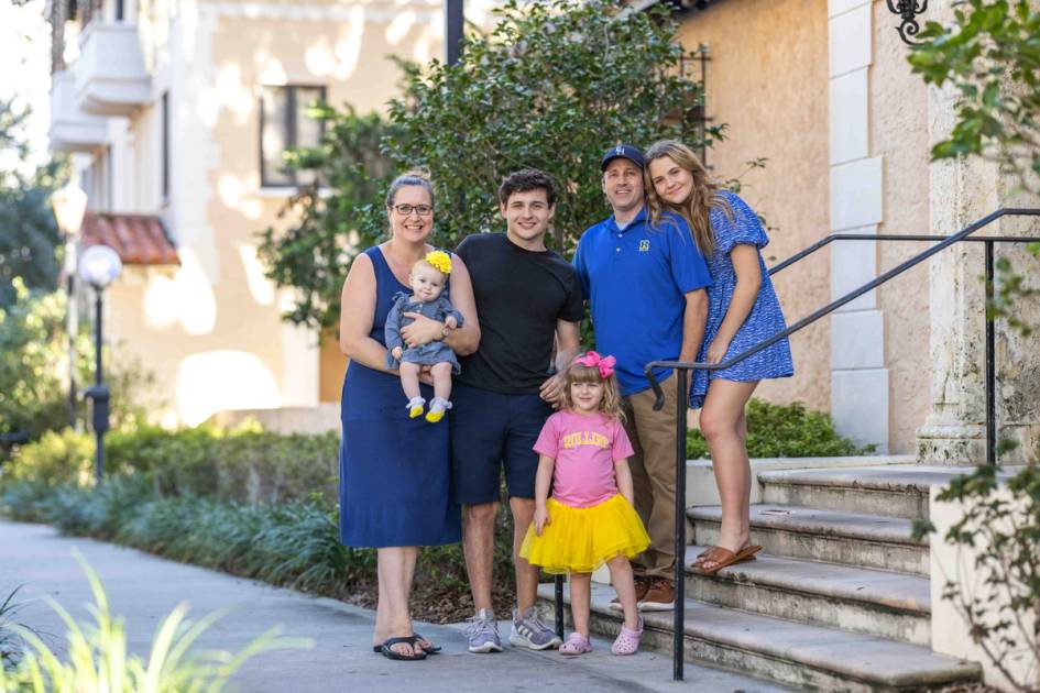 A family of five poses together on Rollins college campus.