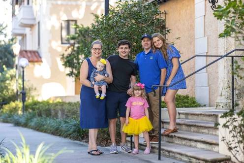 A family of five poses together on Rollins college campus.