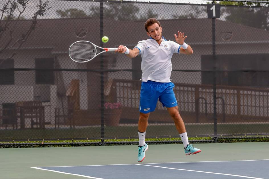 A tennis player returns a shot from the baseline.