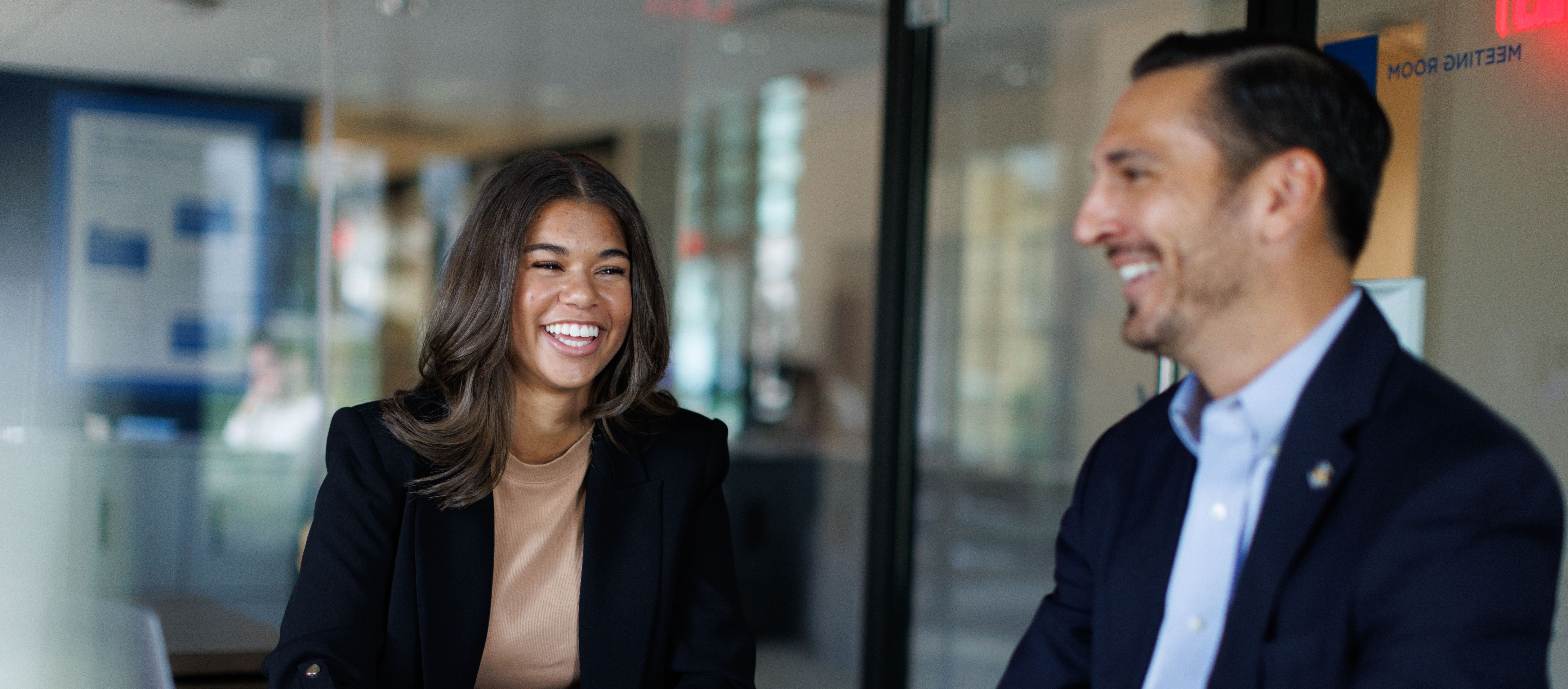 A Rollins employee sits at their desk smiling.