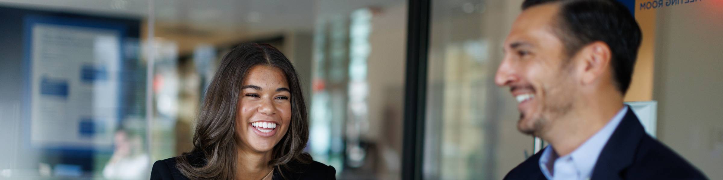 A Rollins employee sits at their desk smiling.