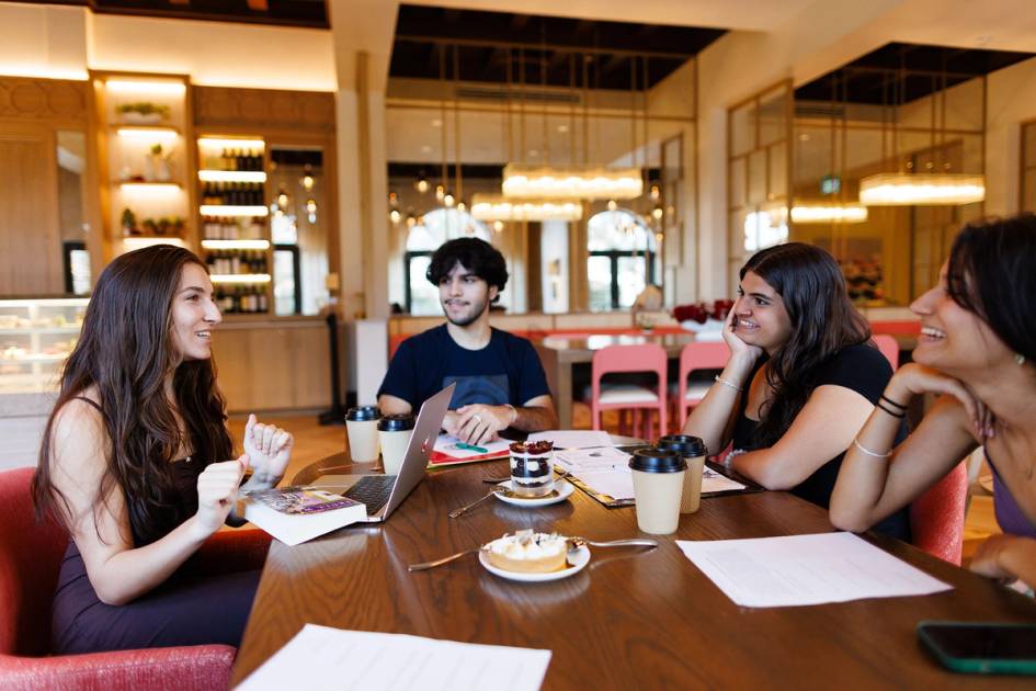 A small group of students talk over coffee.