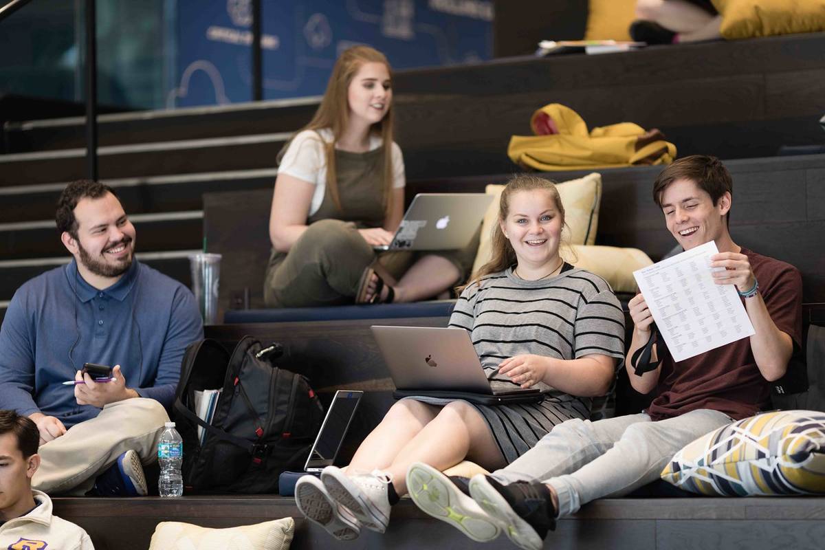 Students sitting on the steps of the KWR atrium