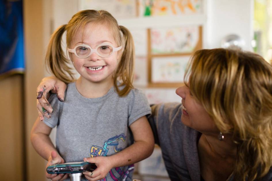 Student smiling at the camera with a teacher