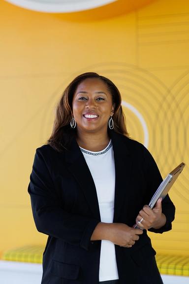 Tiffany Jones poses for a portrait in front of the Google logo in the company’s Atlanta office.