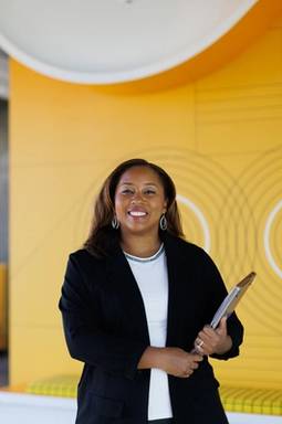 Tiffany Jones poses for a portrait in front of the Google logo in the company’s Atlanta office.