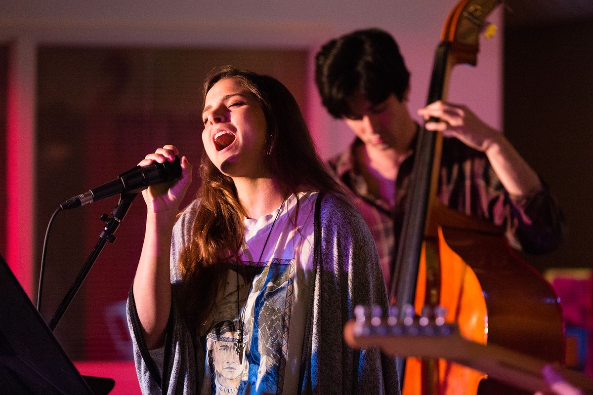 A student sings during a performance on campus.