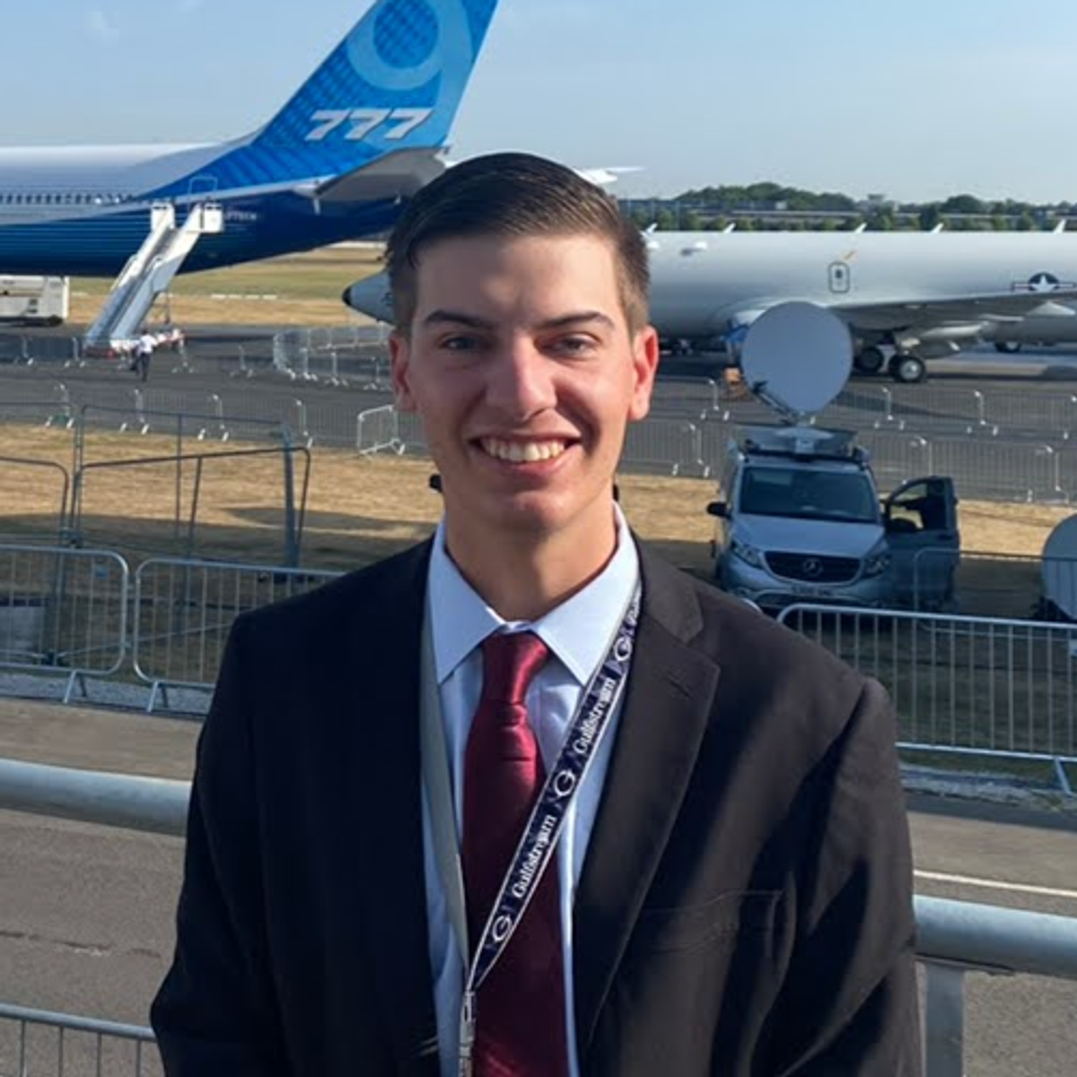 Rollins student Colby MacDonald ‘25 poses in front of a plane