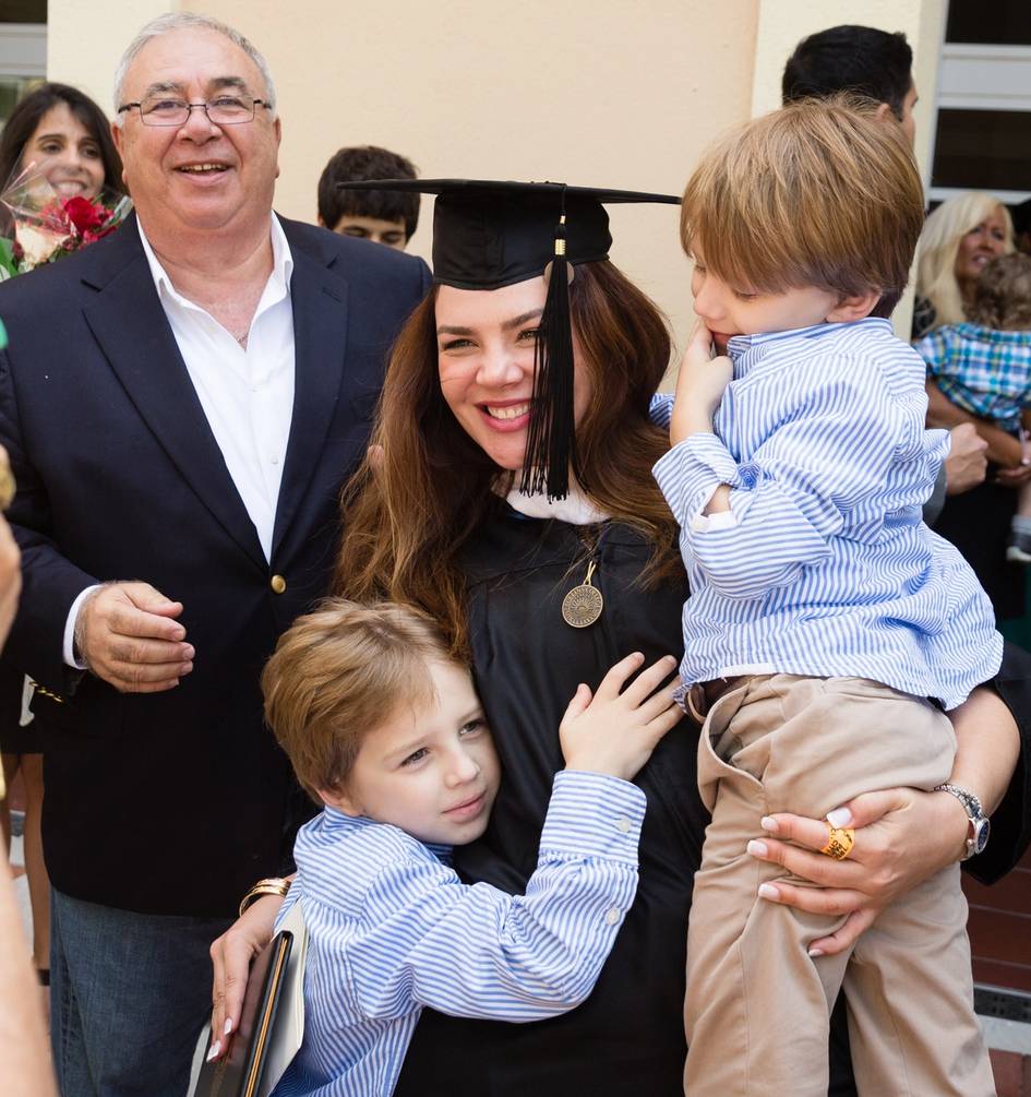 A Rollins graduate poses with her children at commencement.