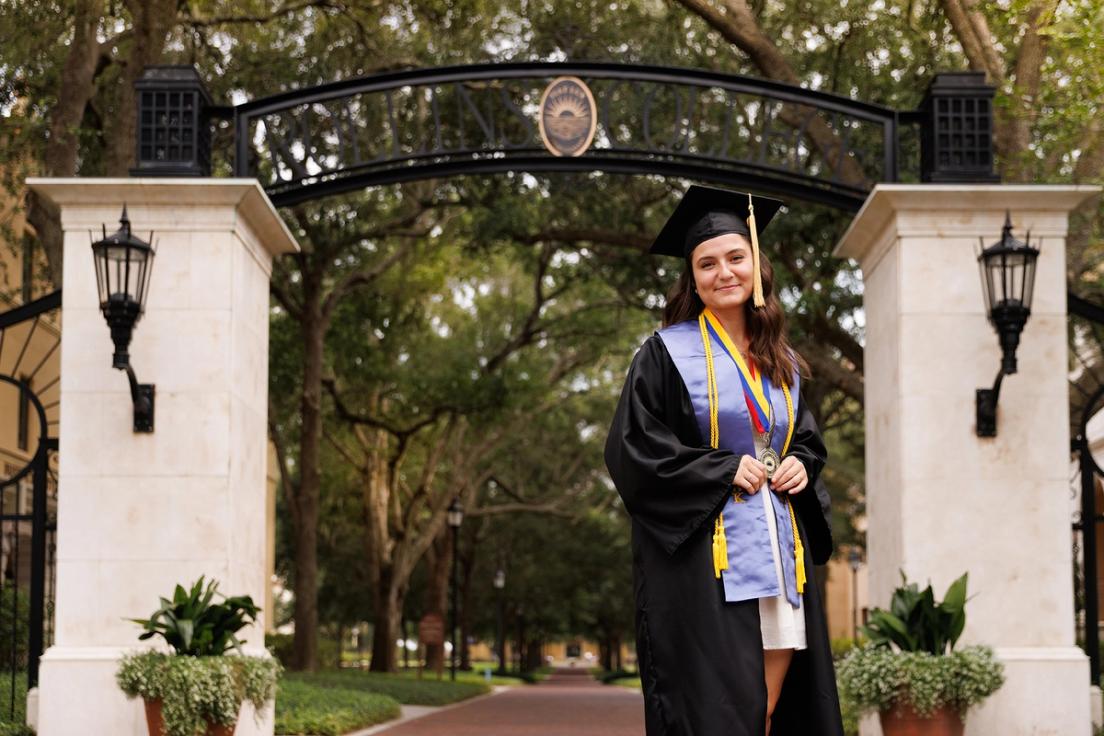 Capri Gutierrez in her cap and gown on the Rollins campus.