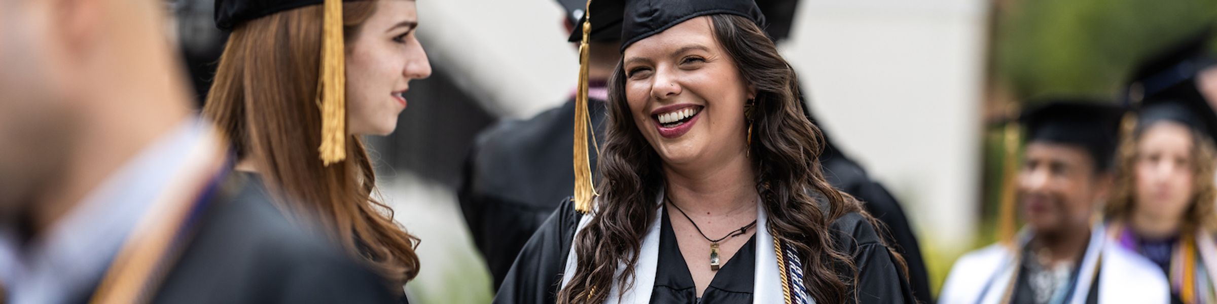 Rollins Professional Advancement graduate stands with a group of students at commencement.