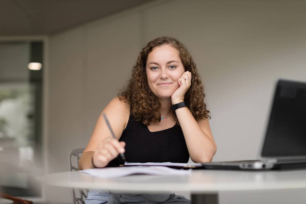 Student poses at her workstation during a summer internship.