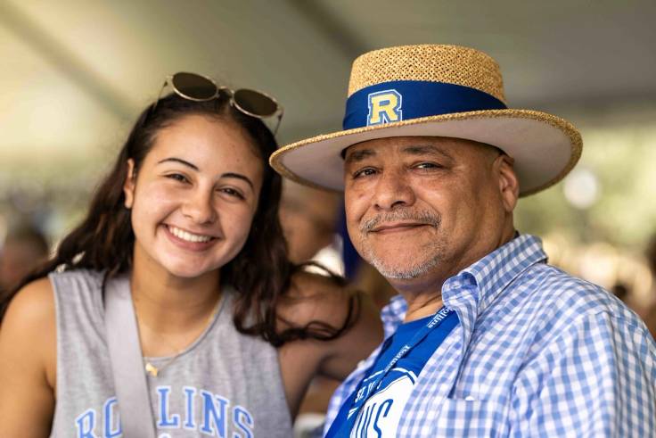 father and daughter in Rollins gear, smiling at an event on Rollins campus