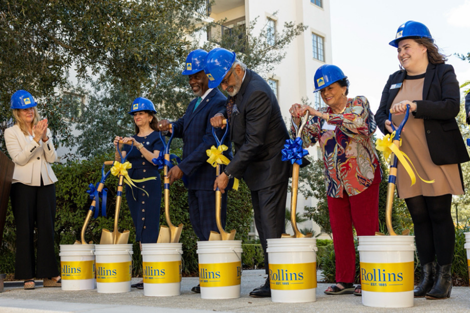 President Barnett claps standing next to people holding shovels with hard hats