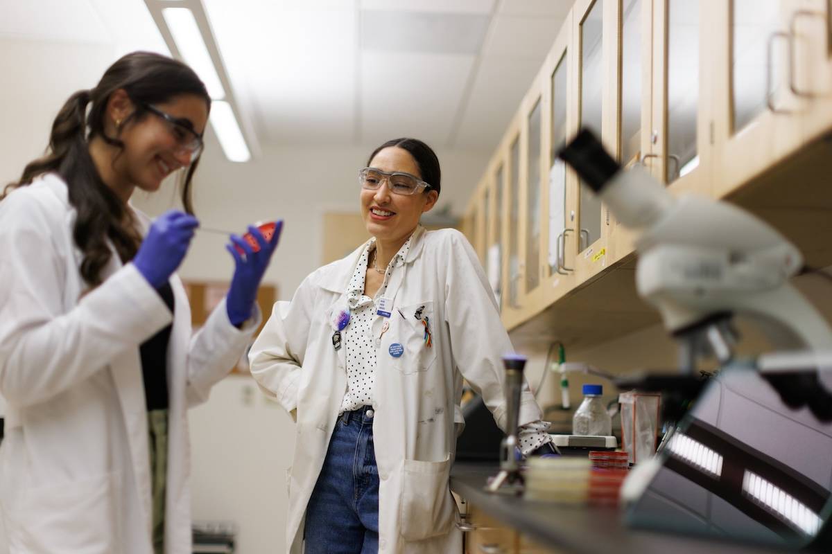 A Rollins College professor and student talk in a lab.
