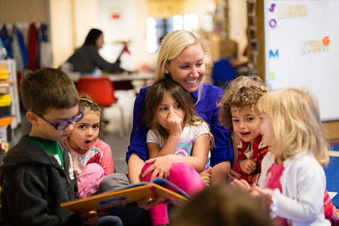 photo of teacher reading to 5 children