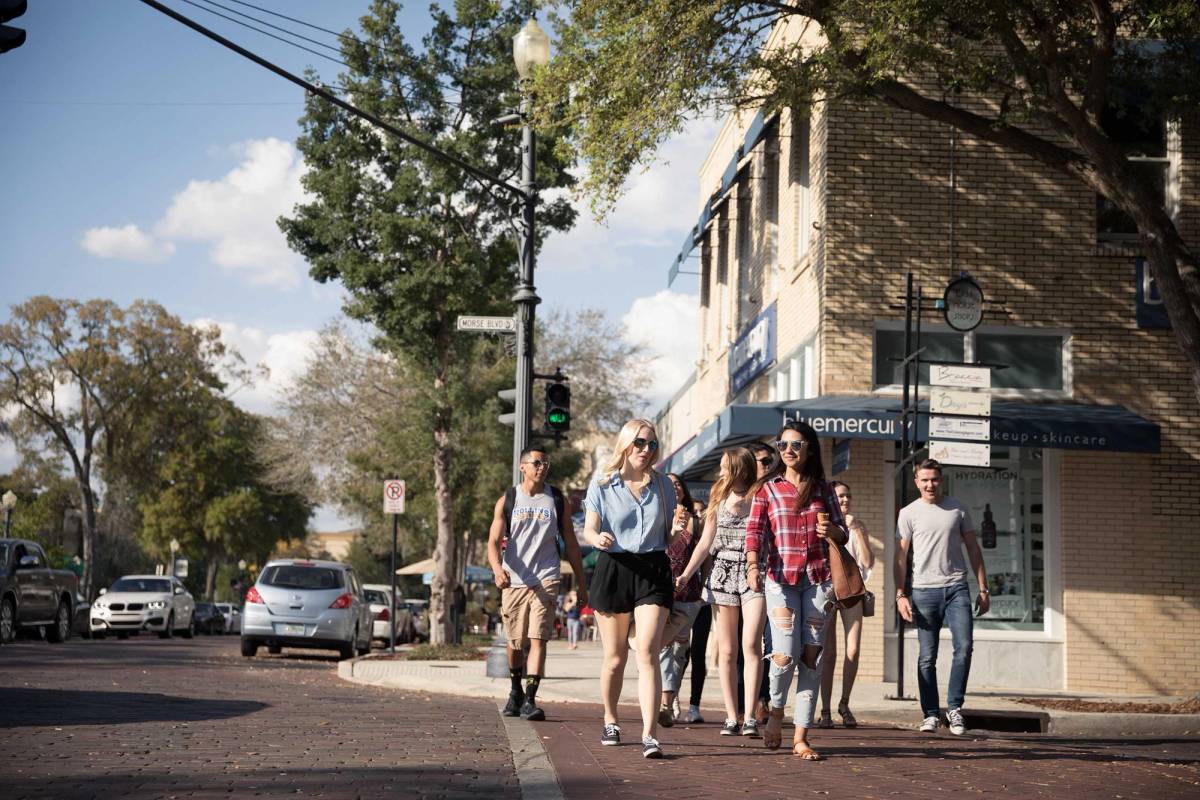 A group of Rollins students walk down Park Avenue.