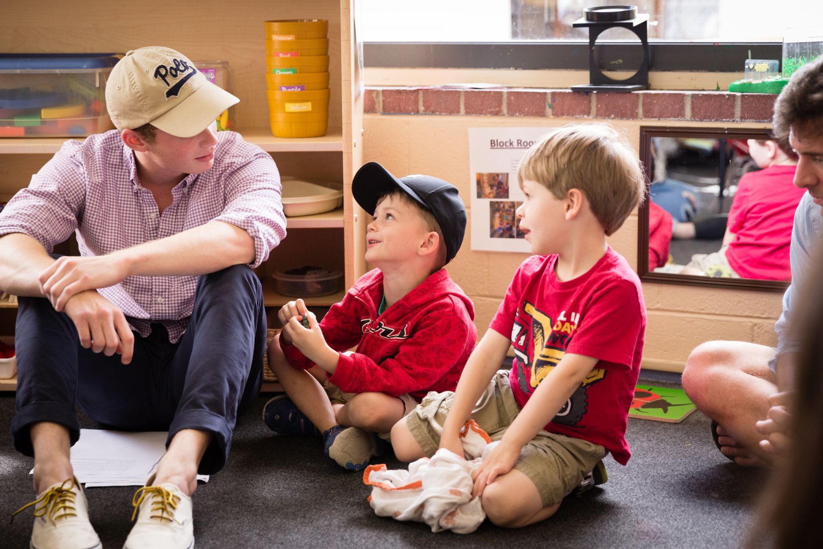 A philosophy student sits with the kids they're tutoring.